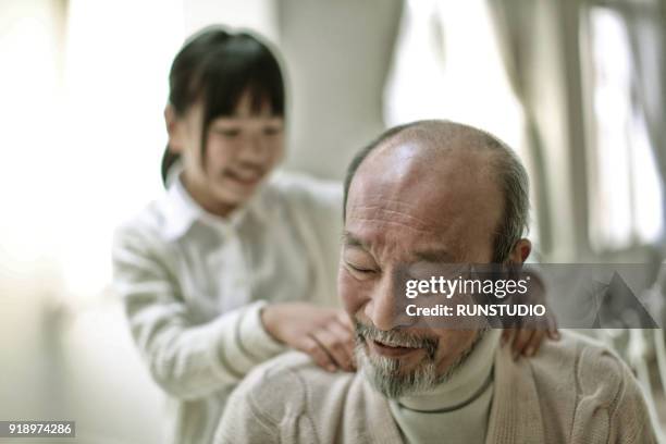 girl massaging grandfather - asian massage girl stock-fotos und bilder