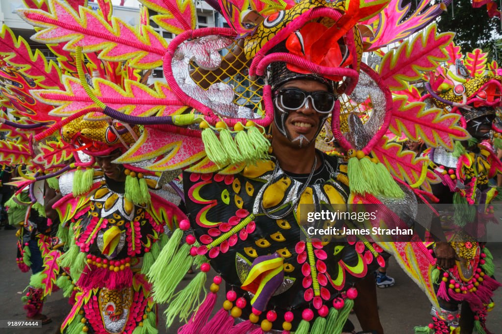 Three participants in flamboyant coloured dress marching at the annual Ati-Atihan Festival, which celebrates the introduction of the Baby Jesus by the Spanish conqusitadors to the black indigenous Ati people, Kalibo Island, Philippines