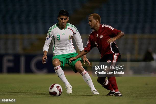 Hayden Tinfo of Trinidad and Tobago vies for the ball with Carlos Salcido of Mexico during their match as part of the 2010 FIFA World Cup Qualifier...