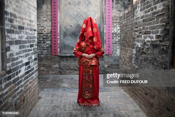 Chinese woman dressed with a traditional bride costume, poses during a wedding performance as part of the She Huo festival, to celebrate the Lunar...