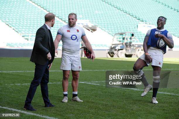Prince Harry shares a joke with England rugby players James Haskell and Maro Itoje as he attends the England rugby team's open training session as...