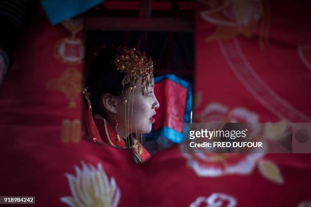 Chinese woman dressed like a traditional bride, attends a wedding performance as part of the She Huo festival, to celebrate the Lunar New Year,...