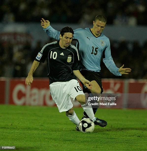 Lionel Messi vies for the ball with Diego Perez of Uruguay during their FIFA World Cup South Africa-2010 qualifier football match at the Centenario...