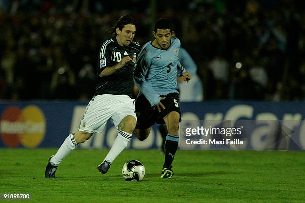 Lionel Messi vies for the ball with Walter Gargano of Uruguay during their FIFA World Cup South Africa-2010 qualifier football match at the...