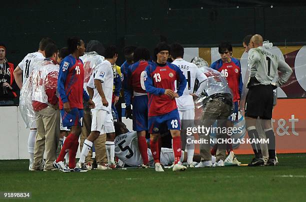 Defender Oguchi Onyewu is surrounded by players after getting injured during a 2010 World Cup qualifier against Costa Rica at RFK Stadium in...