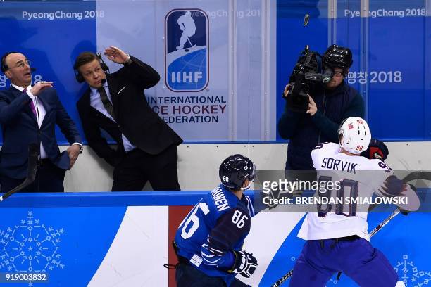 Finland's Veli-Matti Savinainen , Norway's Daniel Sorvik and other watch a puck in mid-air in the men's preliminary round ice hockey match between...