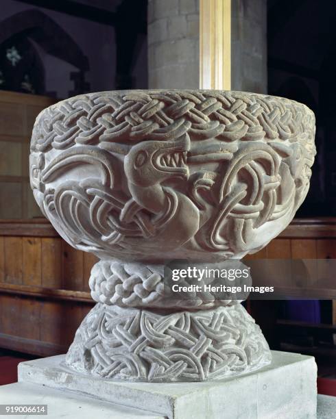 Norman font, Church of St Cassian, Chaddesley Corbett, Worcestershire, circa 2006. Detail of the font showing a carving of a dragon, which dates from...