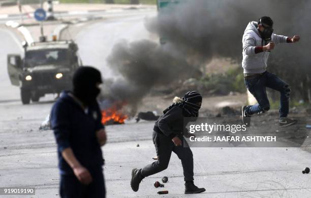 Palestinian demonstrators run for cover during clashes with Israeli forces in the occupied West Bank village of Baita, just outside of Nablus, on...