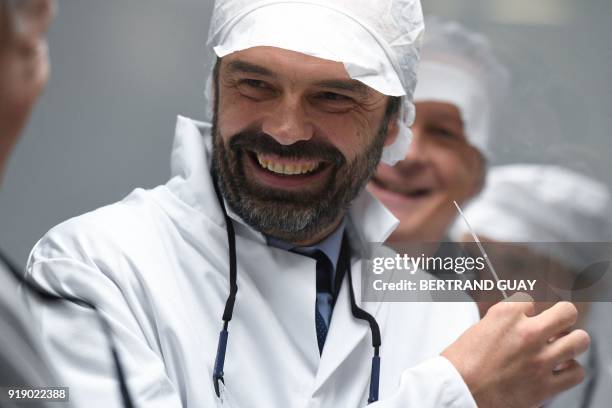 French Prime Minister Edouard Philippe reacts as he smells perfume on a paper stick during a visit of the L'Oreal plant, in Lassigny, on February 16,...