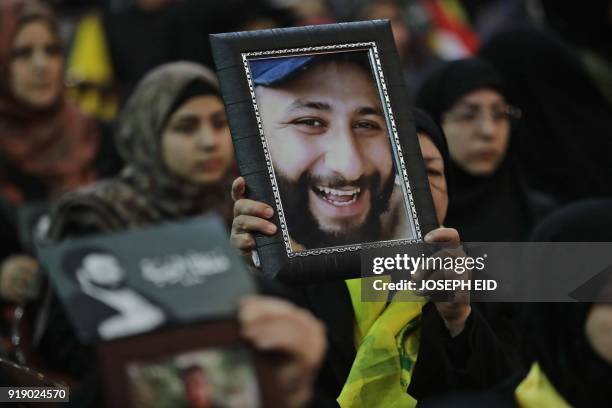 Lebanese woman carries a portrait of her dead son as she attends a gathering for a televised speech held by the Shiite party in the capital Beirut,...