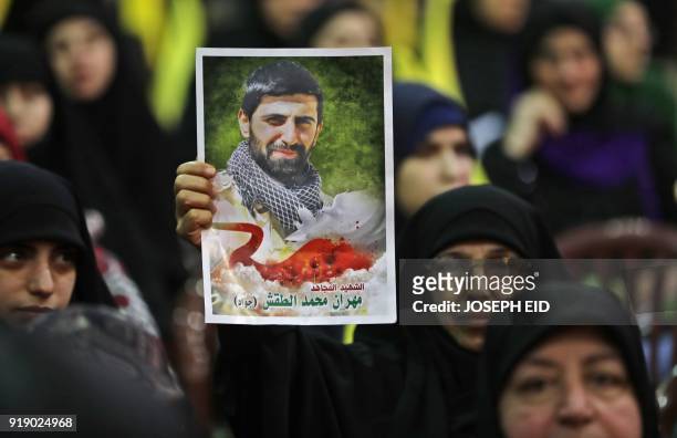 Lebanese woman carries a portrait of her dead son as she attends a gathering for a televised speech held by the Shiite party in the capital Beirut,...