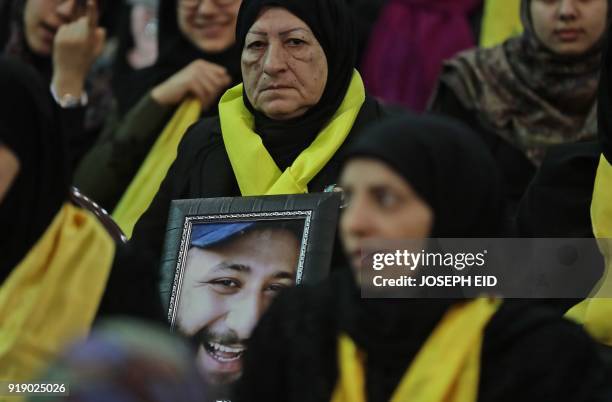 Lebanese woman carries a portrait of her dead son as she attends a gathering for a televised speech held by the Shiite party in the capital Beirut,...