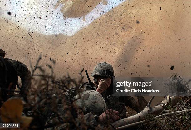 Army soldiers in the 1/501st of the 25th Infantry Division shield their eyes from the powerful rotor wash of a Chinook cargo helicopter as they are...