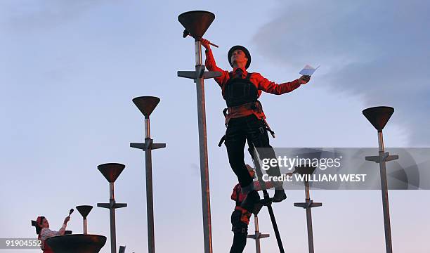 Members of the Melbourne outdoor theatre group Strange Fruit perform 'Ringing the Changes' which sees the performers perched atop five-metre poles...