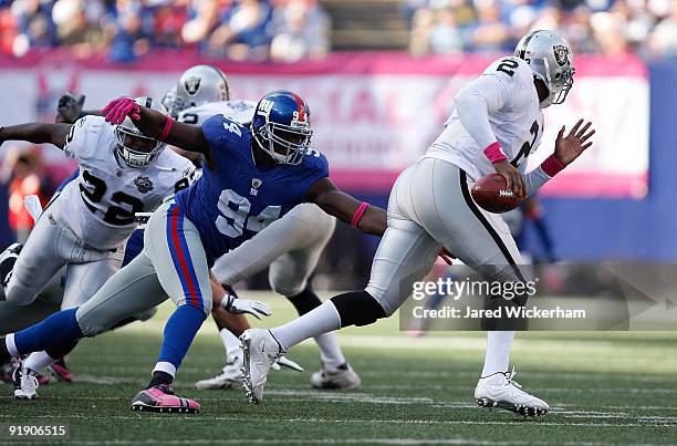 JaMarcus Russell of the Oakland Raiders is chased by Mathias Kiwanuka of the New York Giants during the game on October 11, 2009 at Giants Stadium in...