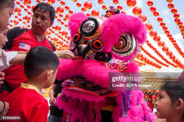 Children seen giving the red envelope to the lion during the lion dance performance at the Thean Hou Temple on the first day of Chinese New Year....