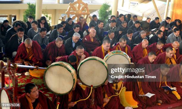 Exiled Tibetan Buddhist monks sit in front of large butter sculptures as they conduct ceremonial prayers to welcome their New Year called Losar on...