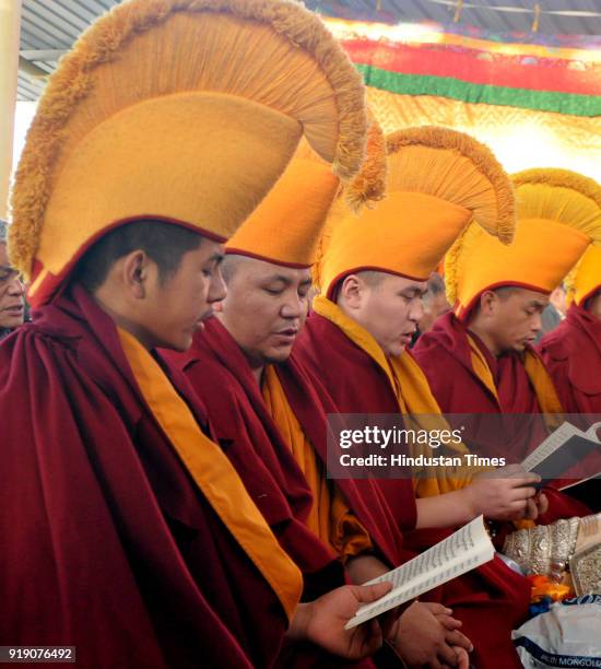 Exiled Tibetan Buddhist monks sit in front of large butter sculptures as they conduct ceremonial prayers to welcome their New Year called Losar on...