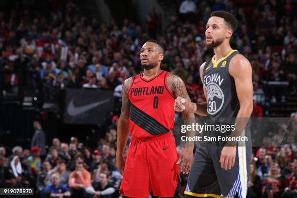 Damian Lillard of the Portland Trail Blazers and Stephen Curry of the Golden State Warriors look on during the game between the two teams on February...