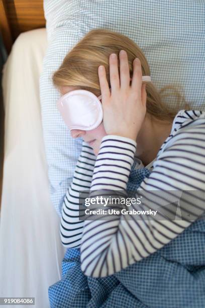 Bonn, Germany Posed Scene: A sick woman lies in bed wearing an eye mask on February 13, 2018 in Bonn, Germany.