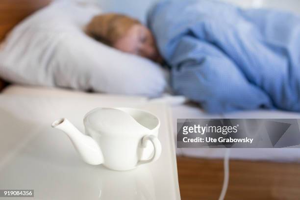 Posed Scene: An Sippy cup stands on a bedside table while a woman is sleeping in bed on February 13, 2018 in Bonn, Germany.