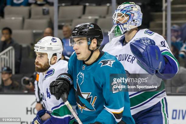 Vancouver Canucks goaltender Anders Nilsson and defenseman Erik Gudbranson wait with San Jose Sharks right wing Timo Meier in front of the Vancouver...