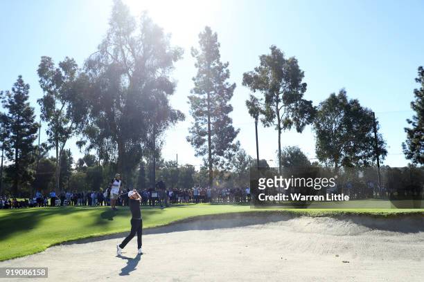 Dustin Johnson plays his shot from the bunker on the second hole during the second round of the Genesis Open at Riviera Country Club on February 16,...