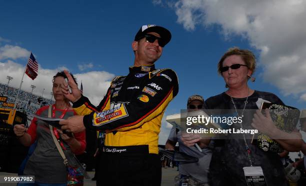 Clint Bowyer, driver of the Rush Truck Centers Ford, signs autographs during practice for the Monster Energy NASCAR Cup Series Daytona 500 at Daytona...