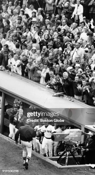 Boston Red Sox fans react to Luis Tiant scoring during a world series game against the Cincinnati Reds at Fenway Park in Boston, Oct. 11, 1975.