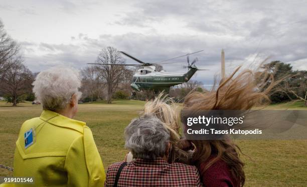 Visitors watch Marine One helicopter depart from the South Lawn of the White House on February 16, 2018 in Washington, DC. The Trumps travel to Mar a...