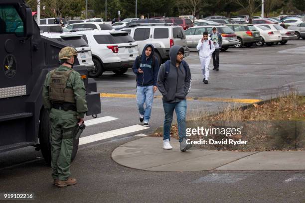 Students exit campus near a SWAT team vehicle after a threat of an active shooter shut down campus at Highline College on February 16, 2018 in Des...