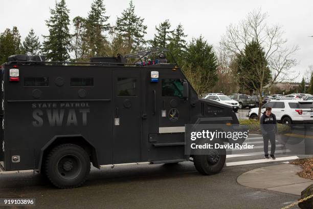 Student exits campus near a SWAT team vehicle after a threat of an active shooter shut down campus at Highline College on February 16, 2018 in Des...