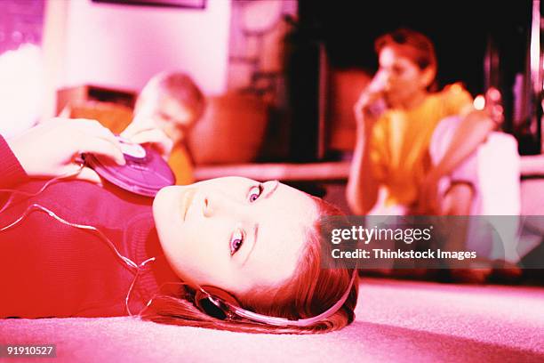 close-up of teenage girl, laying on floor, wearing headset, looking at viewer - personal compact disc player 個照片及圖片檔