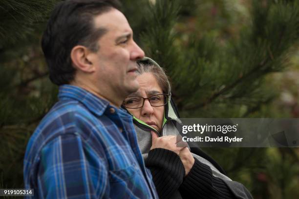 Parents wait to meet their daughter at the edge of a parking lot after a threat of an active shooter shut down campus at Highline College on February...