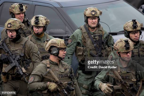 Members of a SWAT team walk through a parking lot after a threat of an active shooter shut down campus at Highline College on February 16, 2018 in...