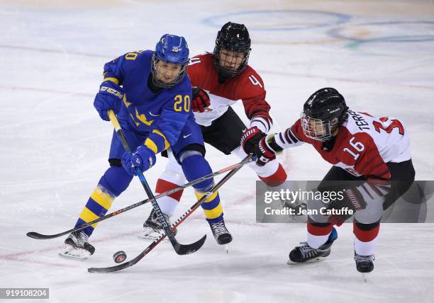 Fany Rask of Sweden, Ayaka Toko and Naho Terashima of Japan during the Women's Ice Hockey Preliminary Round match between Japan and Sweden on day one...