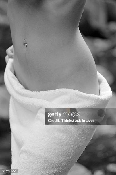 close-up of woman's hips, towel wrapped around her - belly ring stock pictures, royalty-free photos & images