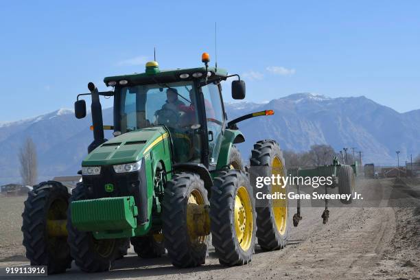 Candidate for senate Mitt Romney at the wheel of a John Deere tractor as he tours Gibson's Green Acres Dairy on February 16, 2018 in Ogden, Utah. Mr....