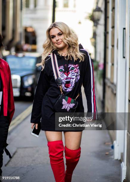 Tallia Storm wearing Gucci bag, red overknees boots seen outside Mulberry during London Fashion Week February 2018 on February 16, 2018 in London,...
