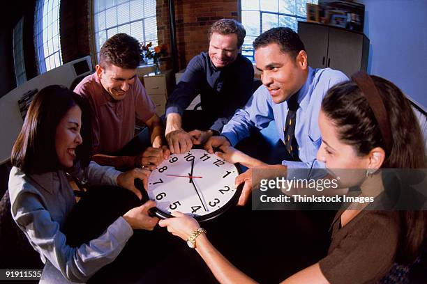 fisheye view of group of professionals seated around table, fighting over clock - fish eye photos et images de collection