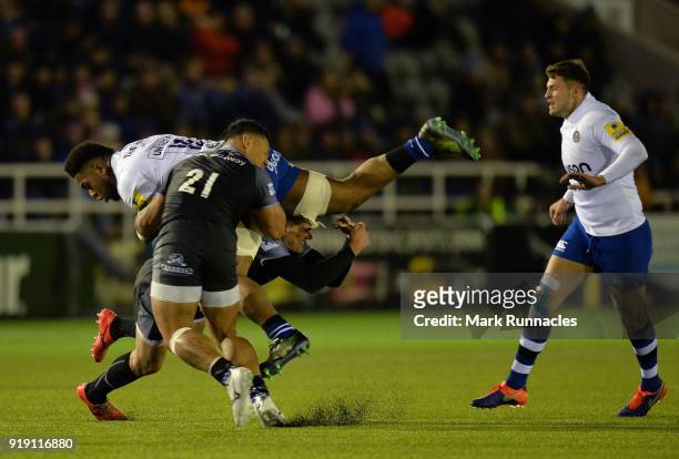Levi Douglas of Bath Rugby is tackled by Toby Flood and Sonatane Takulua of Newcastle Falcons during the Aviva Premiership match between Newcastle...