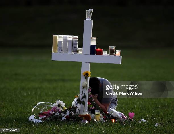 Young boy sits a memorial cross that honors victims of the mass shooting at Marjory Stoneman Douglas High School, at Pine Trail Park on February 16,...