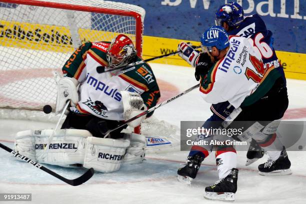 Yannic Seidenberg , of Mannheim tries to score a goal against Steve Junker and goalkeeper Dennis Endras of Augsburg during the DEL match between...