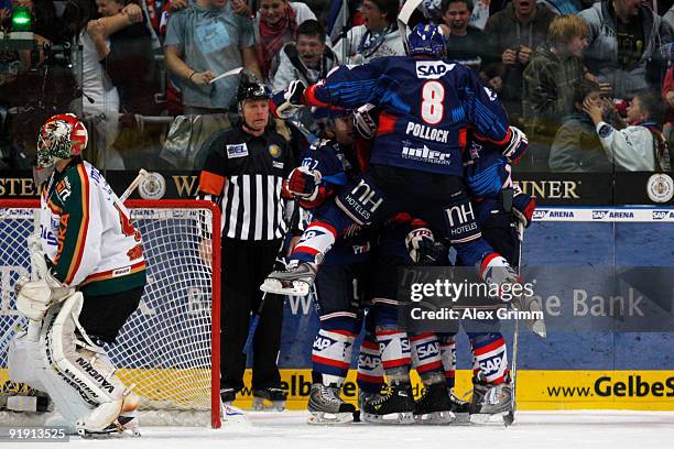 James Pollock of Mannheim jumps on his team mates to celebrate their team's second goal as goalkeeper Dennis Endras of Augsburg reacts during the DEL...