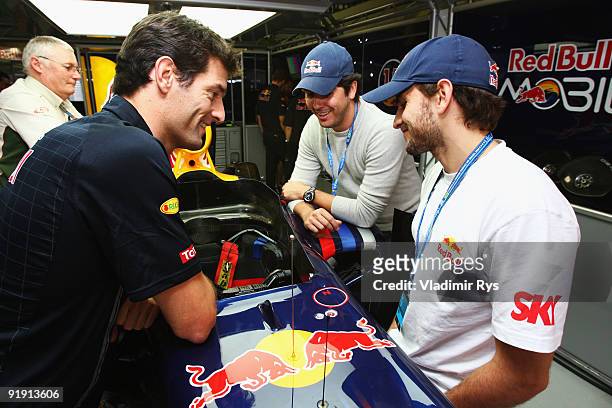 Carlos "Cacá" Bueno and Daniel Serra meet Mark Webber of Australia and Red Bull Racing during previews to the Brazilian Formula One Grand Prix at...