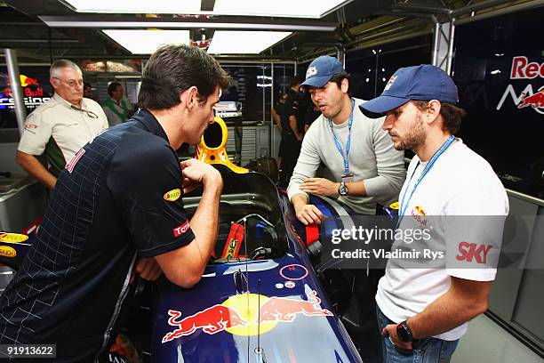 Carlos "Cacá" Bueno and Daniel Serra meet Mark Webber of Australia and Red Bull Racing during previews to the Brazilian Formula One Grand Prix at...