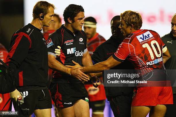Jonny Wilkinson of Toulon shakes hands with Bradley Barritt of Saracens after a tackle which lead to Barritt leaving the field injured during the...