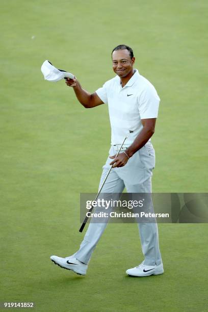 Tiger Woods acknowledges fans after finishing his round on the 18th green during the second round of the Genesis Open at Riviera Country Club on...