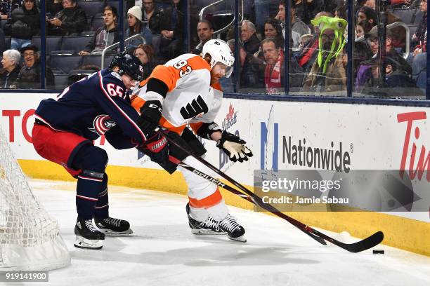 Jakub Voracek of the Philadelphia Flyers attempts to shield the puck from Markus Nutivaara of the Columbus Blue Jackets during the second period of a...