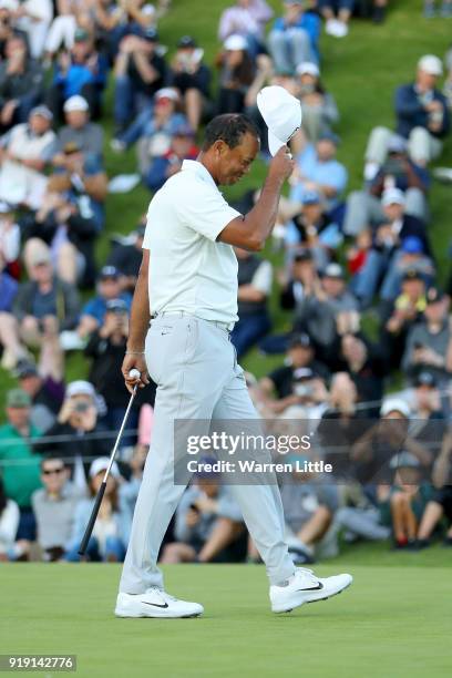 Tiger Woods acknowledges fans after finishing his round on the 18th green during the second round of the Genesis Open at Riviera Country Club on...